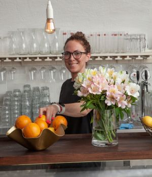 Freundliche Barkeeperin mit frischen Zutaten in der Bar von Rabinas Hofpassage Eisenstadt
